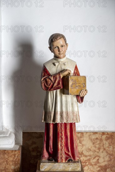 Model of young boy holding offertory collecting box at exit of church, Frigiliana, Malaga province,