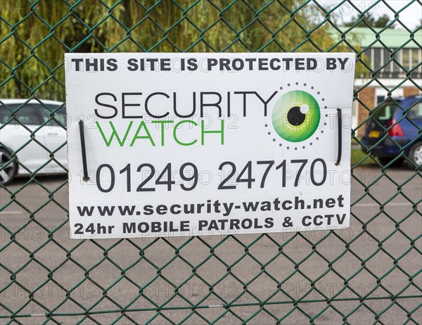 Security protection sign on wire fence, Porte Marsh Industrial Estate, Calne, Wiltshire, England,