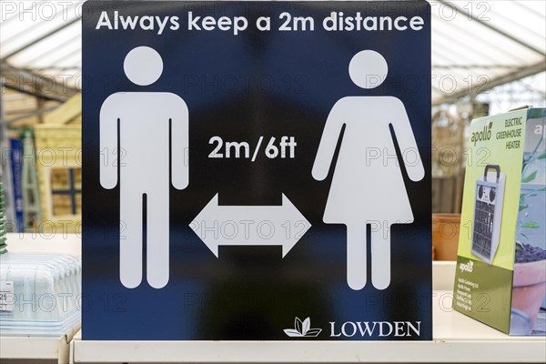 Social Distancing 2 metres apart information notice sign in Lowden garden centre shop, Wiltshire,