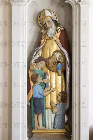 Sculpture statue of Saint Nicholas with children inside village parish church of Saint Nicholas,