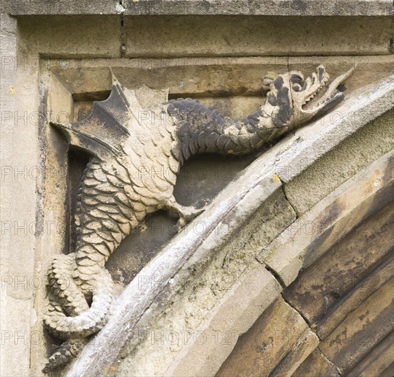 Mythological folklore figure of a griffin dragon carved in stone on the entrance doorway to the