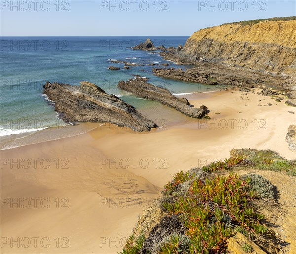 Sandy beach Praia dos Alteirinhos, Zambujeira do Mar in bay between rocky headlands part of Parque