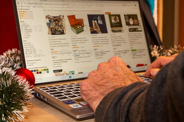 Symbolic image of Christmas shopping on the internet/at Amazon: Christmas decorations and laptop