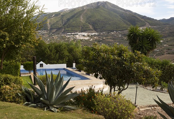 Swimming pool in garden small hotel view to Alcaucin village and Maroma mountain, Sierra de Tejeda,