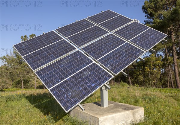 Solar panel array in rural location of field in countryside providing domestic energy near village