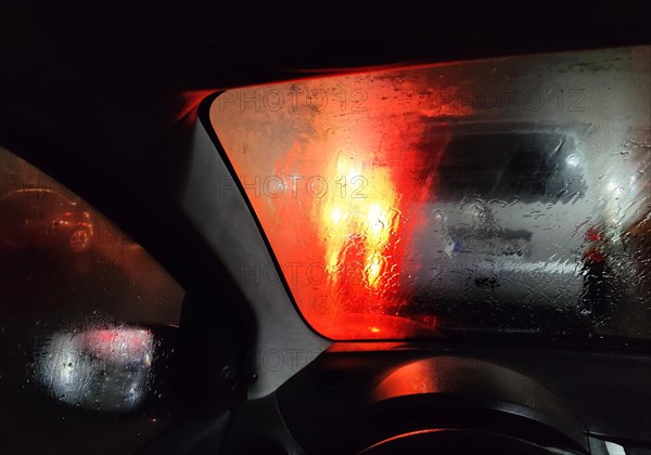 View from the car in dangerously poor visibility at night with rain and blinding backlight,