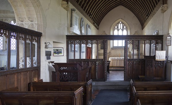 Wooden chancel screen dating from 15th, 16th century looking down to altar and east window inside