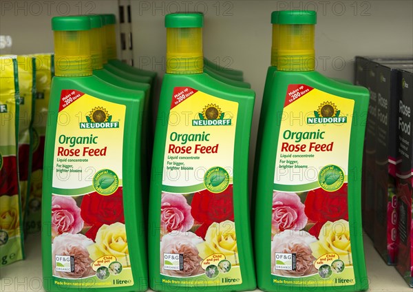 Plastic containers of Neudorff Organic Rose Feed liquid concentrate on shelf display in garden