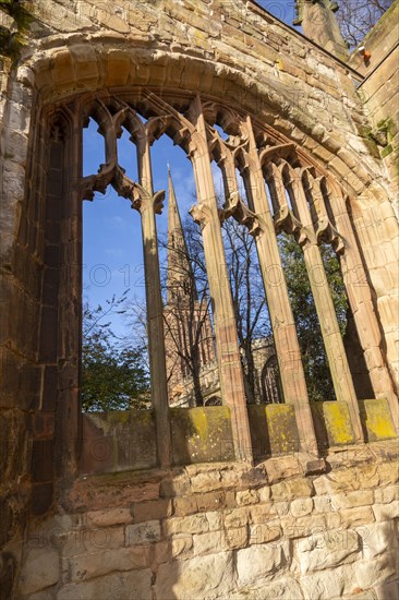 Steeple of Holy Trinity church seen through bombed out windows of old cathedral, Coventry, England,