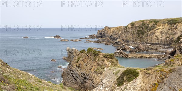 Rocky rugged coastline near fishing port village of Azenha do Mar, Alentejo Littoral, Portugal,