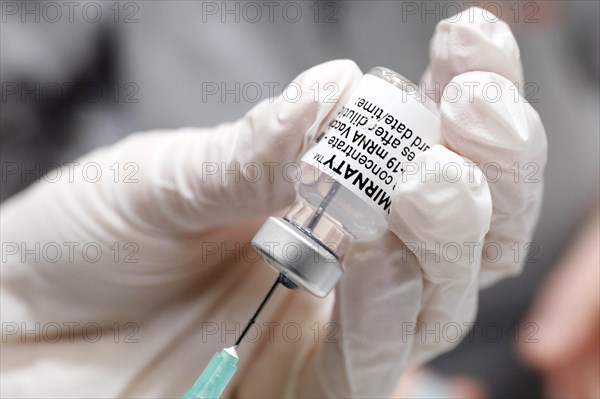 Drawing up a syringe with the Biontech Pfizer active ingredient Comirnaty against Covid19 in a