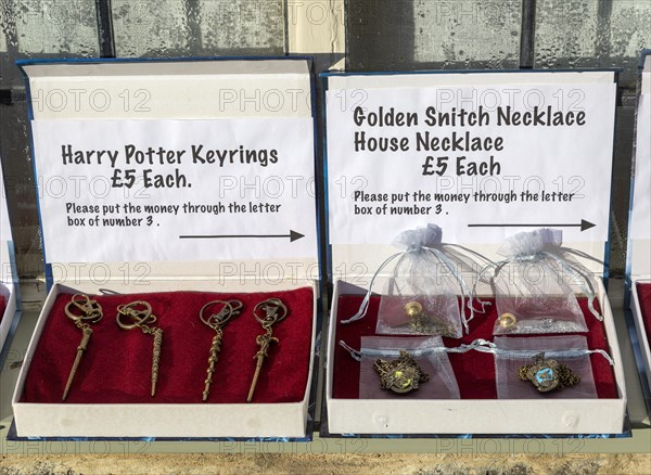 Display boxes Harry Potter souvenir products on sale on trust outside house, Lacock, Wiltshire,