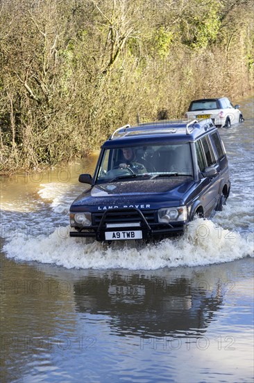 Land Rover Discovery Td5 vehicle driving through flood water at Kellaways, Wiltshire, England, UK