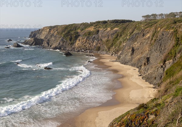 Secluded sandy beach in bay between rocky headlands at Parque Natural do Sudoeste Alentejano e