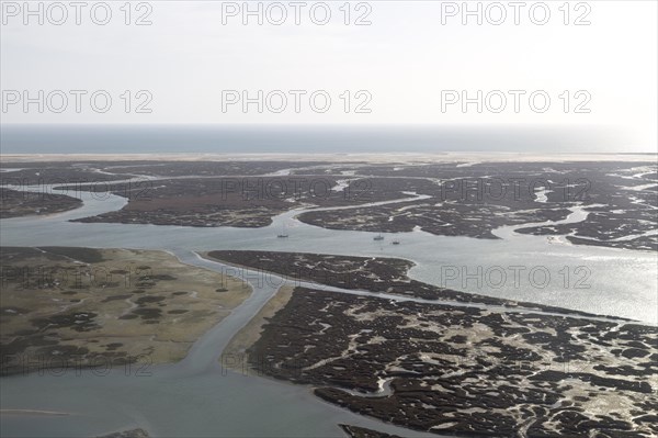 Coastal landscape of salt marsh and drainage channels along the coastline off Faro, Algarve,