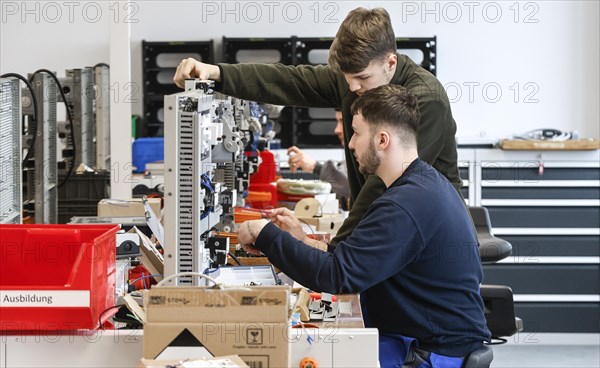 An electronics apprentice assembles a motor protection relay at a Deutsche Bahn training centre,