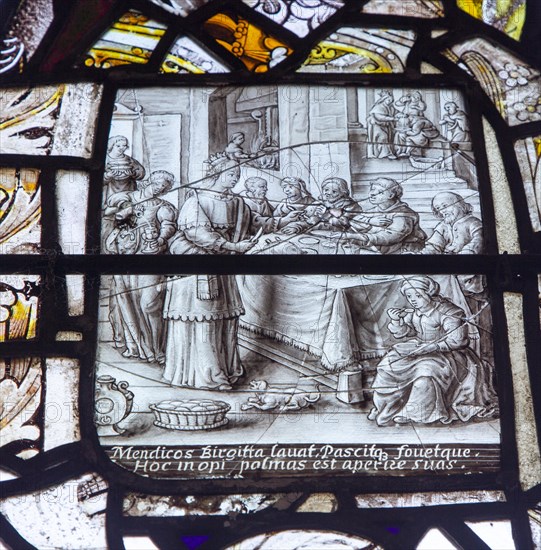 Stained glass window in All Saints church, Eyke, Suffolk, England, UK, Saint Bridget feeding the
