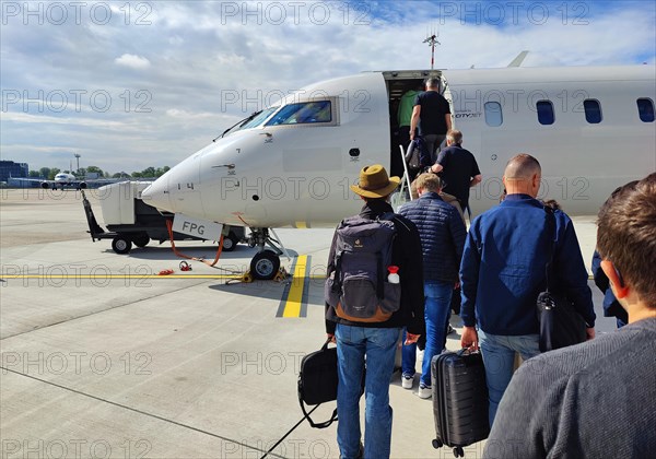 Passengers with hand luggage boarding a small aircraft on the tarmac, Duesseldorf Airport, North
