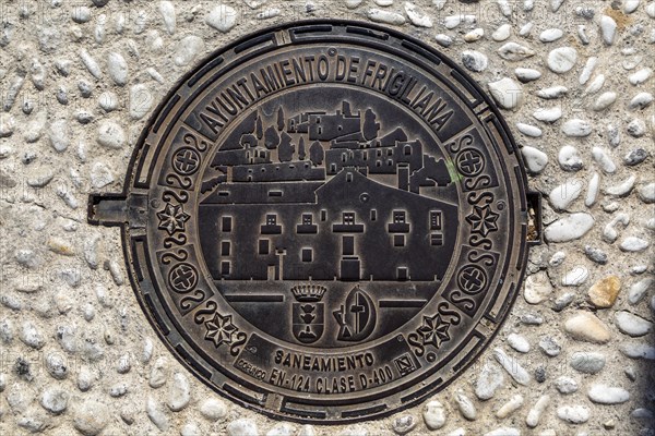 Looking down at metal manhole cover design image of village, Frigiliana, Axarquia, Andalusia,