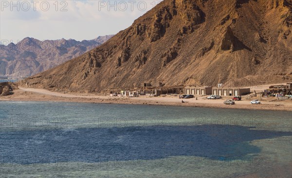 The coastline of the Red Sea with small resorts and the mountains in the background. Coral reef
