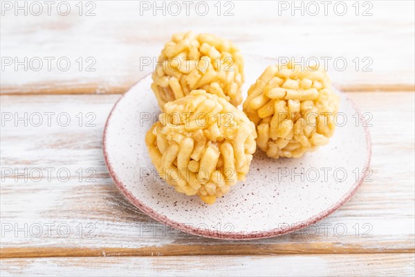 Traditional Tatar candy chak-chak made of dough and honey on a white wooden background. Side view,