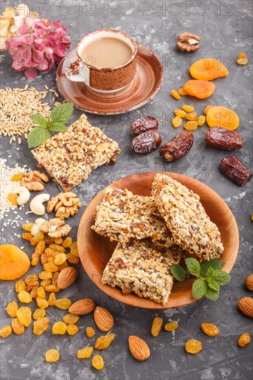 Homemade granola from oat flakes, dates, dried apricots, raisins, nuts with a cup of coffee on a