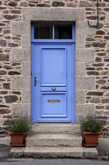 House facade with blue entrance door and two flower pots on steps, Pontrieux, Departement Cotes