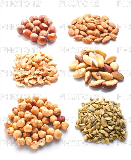 Piles of various nuts and seeds isolated on white background. hazelnut, brazil nut, almond, pumpkin