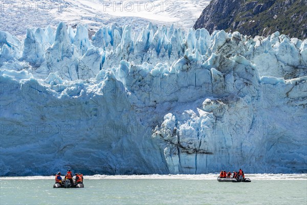 Passengers of the cruise ship Stella Australis in rubber dinghies in front of the ice of the Porter