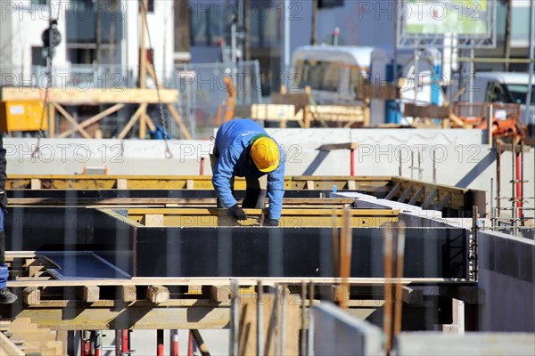 Construction work on the foundations of a large apartment building. The construction workers are