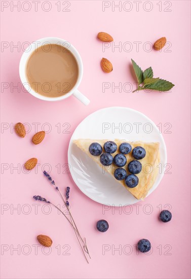 Homemade layered Napoleon cake with milk cream. Decorated with blueberry, almonds, mint on a pastel