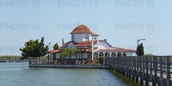 Small church with tiled roof on the water's edge with connection via a bridge, Monastery of St