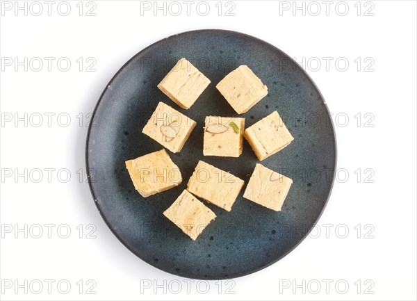 Traditional indian candy soan papdi in blue ceramic plate isolated on a white background. top view,