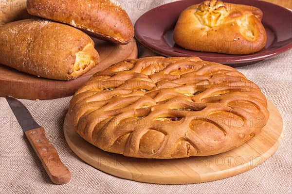 Sweet buns on a wooden board and linen tablecloth