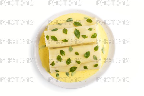 Cannelloni pasta with egg sauce, cream cheese and oregano leaves isolated on white background. top