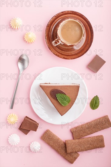 Cake with souffle milk chocolate cream with cup of coffee, meringues on a pink pastel background.