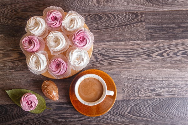 Pink and white homemade marshmallows (zephyr) with cup of coffee on a gray wooden background. top