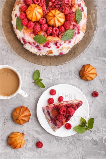 Homemade jelly cake with milk, cookies and raspberry on a gray concrete background with cup of