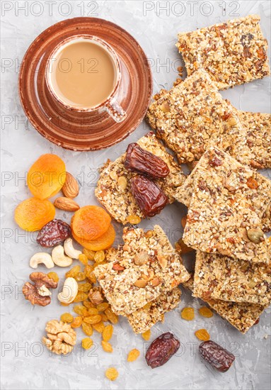 Homemade granola from oat flakes, dates, dried apricots, raisins, nuts with a cup of coffee on a