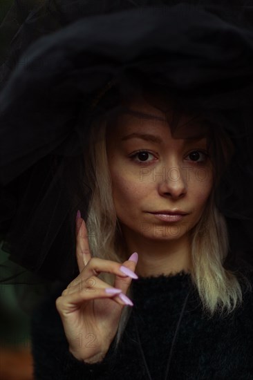 Moody portrait of a woman with a contemplative expression making a hand gesture