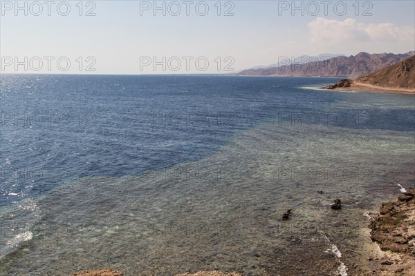 The coastline of the Red Sea with small resorts and the mountains in the background. Coral reef