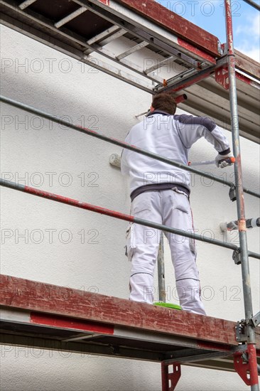 Painter painting the facade of a new residential building