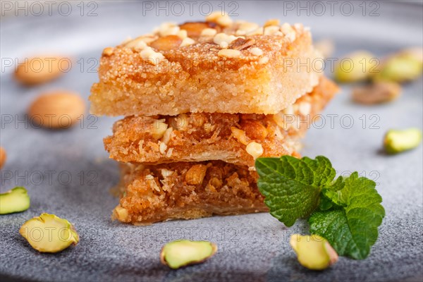 Traditional arabic sweets in gray ceramic plate on a gray concrete background. side view, close up,