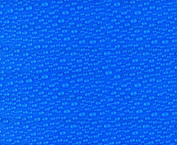 Many small water drops on a blue surface