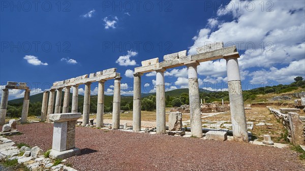 Row of ancient columns under a bright blue sky on an archaeological site, Stoa of the Agora,