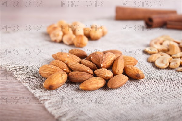Cinnamon, almonds, hazelnuts, cashew on a linen napkin. Still life. Closeup