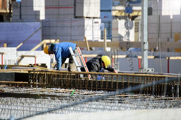 Construction work on the foundations of a large apartment building. The construction workers are