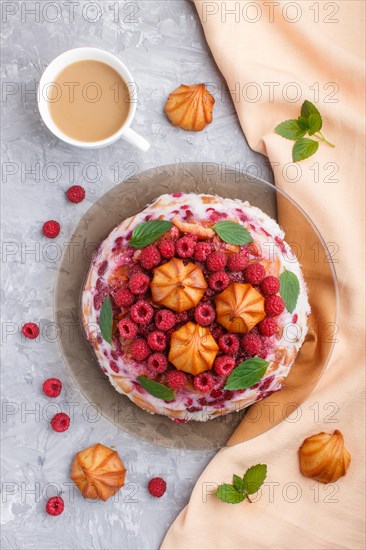 Homemade jelly cake with milk, cookies and raspberry on a gray concrete background with cup of