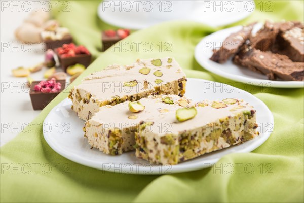Traditional arabic sweets sesame halva with chocolate and pistachio and a cup of coffee on green