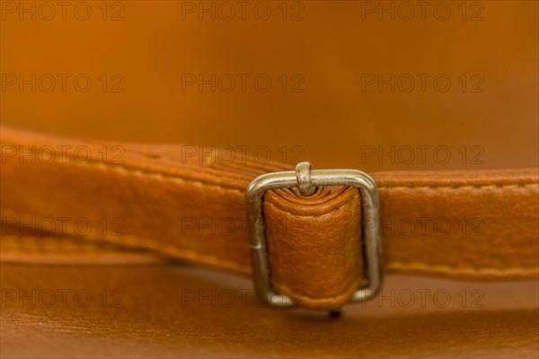 Metal adjustment clip on strap of leather shoulder bag